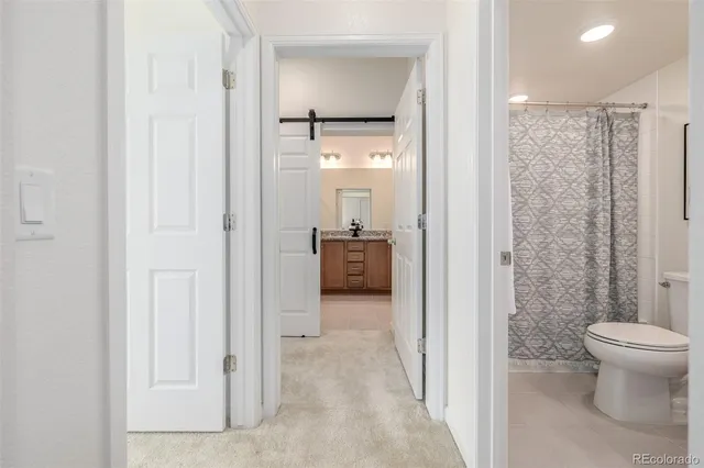 a bathroom with a granite countertop toilet sink and mirror