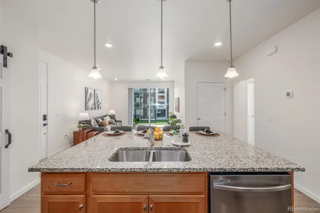 a kitchen with kitchen island granite countertop a sink and large window