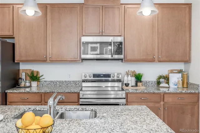 a kitchen with stainless steel appliances granite countertop a stove a sink and a white cabinets