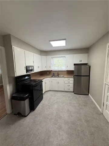 a bathroom with a granite countertop toilet a sink a mirror and a window