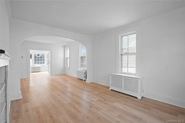 an empty room with windows and cabinet