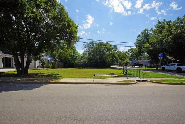 a view of swimming pool with a yard and palm trees