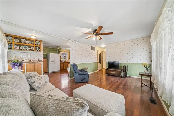 a living room with furniture ceiling fan and a wooden floor