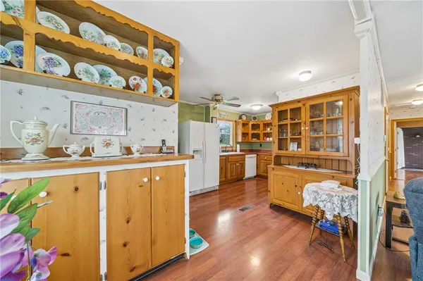 a living room with stainless steel appliances kitchen island granite countertop wooden floors and a view of living room