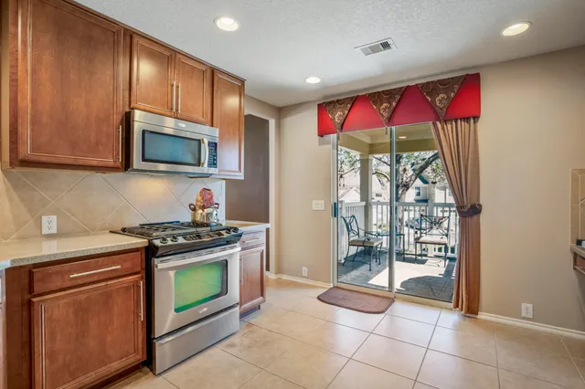 a kitchen with stainless steel appliances granite countertop a refrigerator and a stove top oven