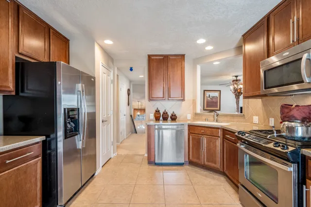 a kitchen with stainless steel appliances granite countertop a stove a sink and a microwave