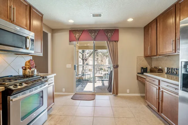 a kitchen with stainless steel appliances granite countertop wooden cabinets stove top oven and sink