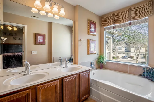 a bathroom with a tub a sink and a window