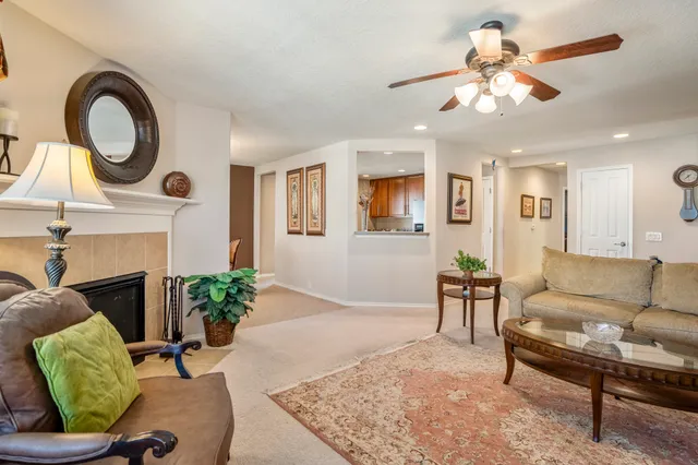 a living room with furniture a fireplace and a chandelier