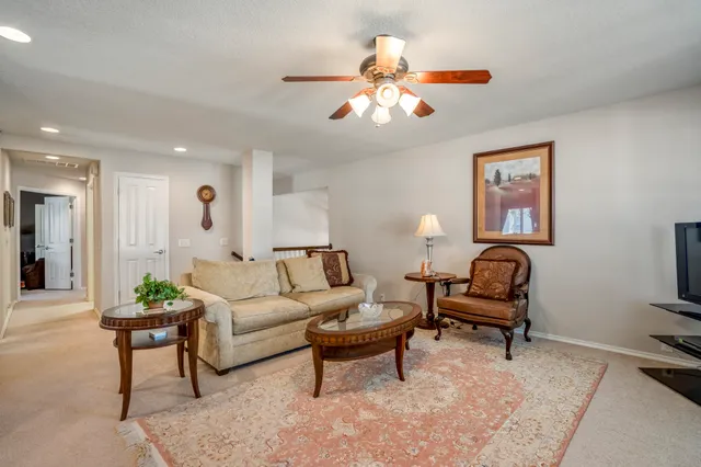 a living room with furniture a piano and a flat screen tv