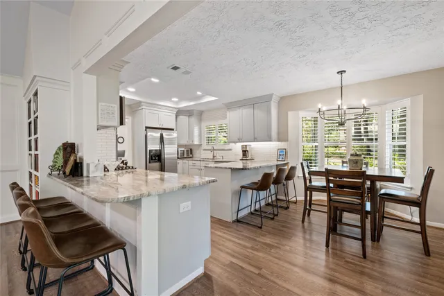 a dining room with kitchen island stainless steel appliances furniture a dining table and chairs