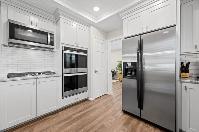 a kitchen with stainless steel appliances and wooden floor