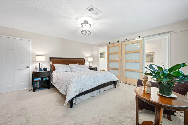a bedroom with a large bed and a chandelier