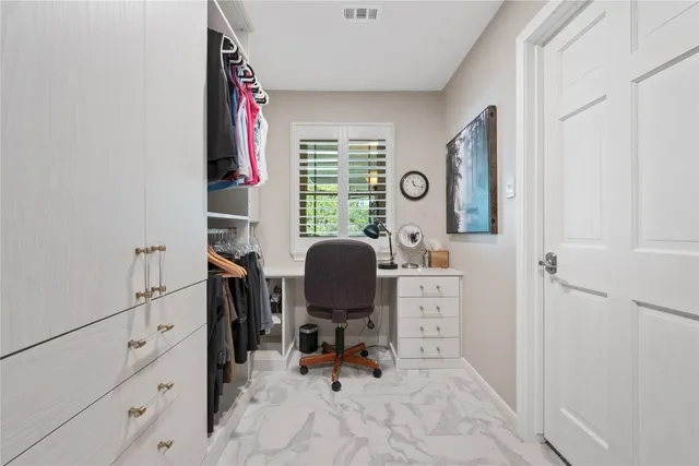 a view of a workspace with furniture and a window