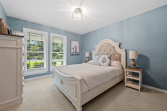 a large bed sitting in a bedroom next to a window