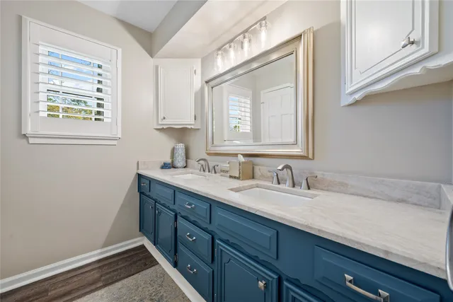 a bathroom with a granite countertop sink a vanity and a window
