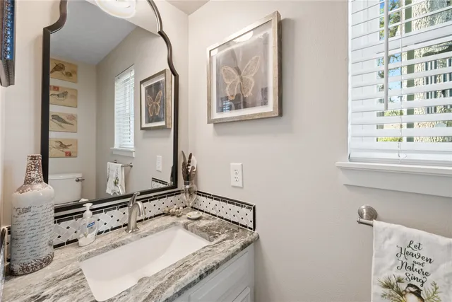 a bathroom with a granite countertop sink and a mirror