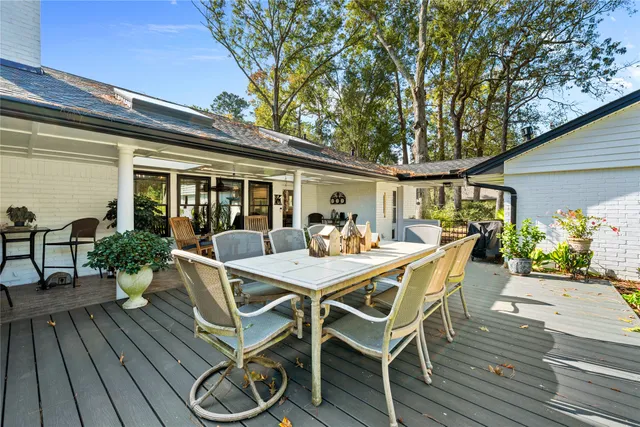a view of a patio with table and chairs with wooden floor and fence