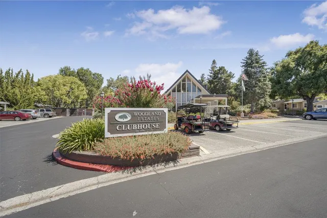 a view of a patio with a table and chairs next to a road
