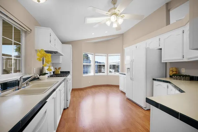 a kitchen with a refrigerator a stove cabinets and wooden floor