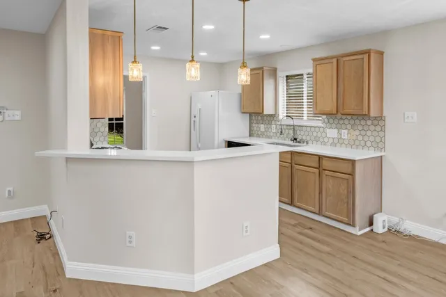 a kitchen with a sink a counter top space stainless steel appliances and cabinets