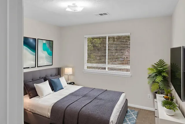 a bed sitting in a bedroom next to a window