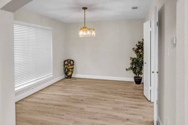 a view of empty room with wooden floor and window