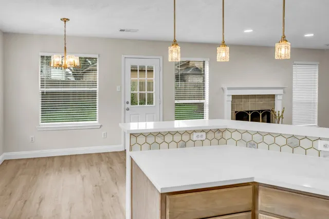 a view of kitchen with granite countertop cabinets and window