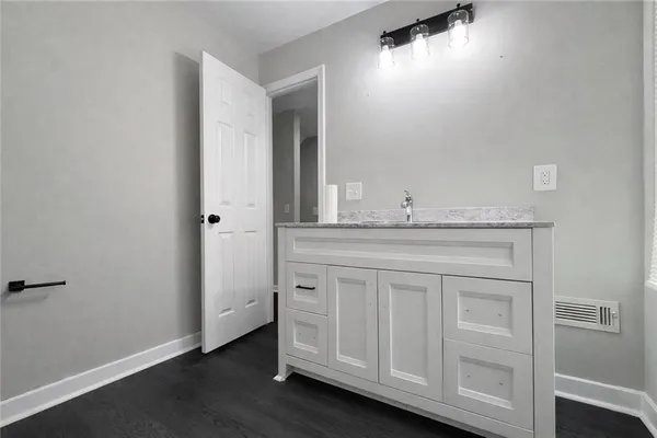 a bathroom with a granite countertop sink and a mirror
