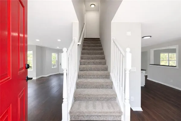 a view of an entryway with wooden floor and stairs
