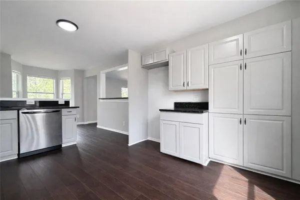a kitchen with a refrigerator and white cabinets