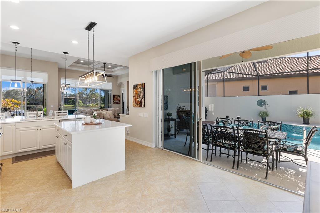 12612 Grandezza Circle Estero, FL 33928 - Photo 11 of 48 Kitchen with sink, white cabinetry, a center island, hanging light fixtures, and light tile patterned floors
