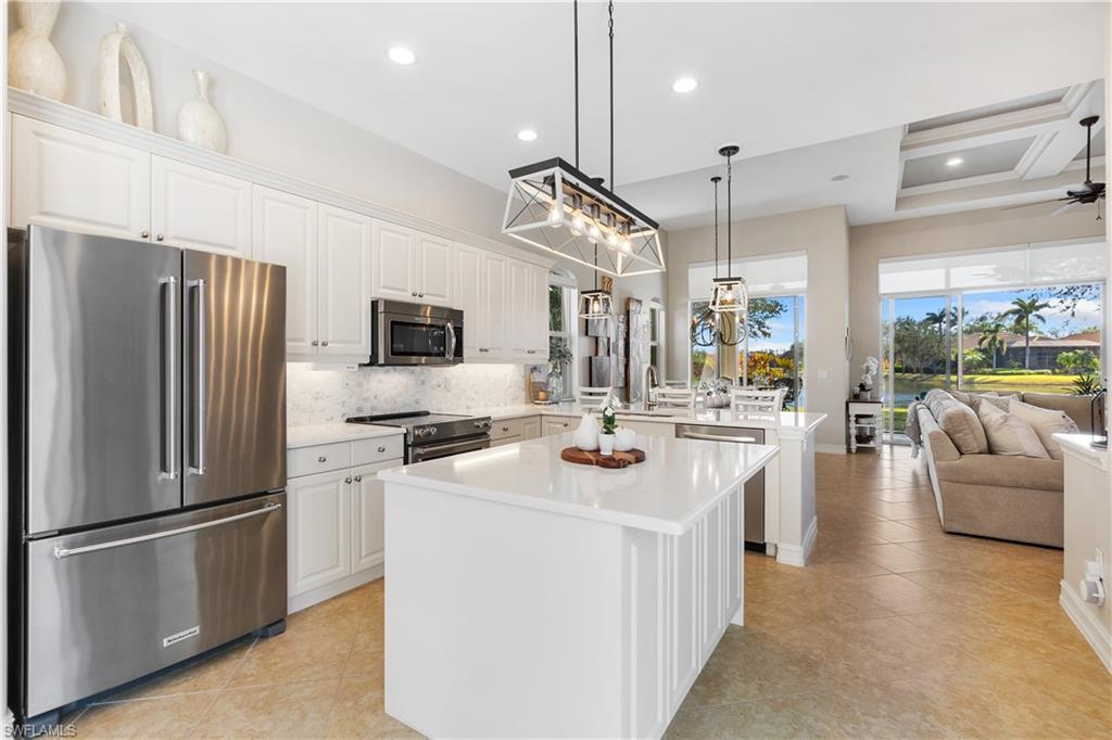 12612 Grandezza Circle Estero, FL 33928 - Photo 12 of 48 Kitchen featuring white cabinets, hanging light fixtures, a kitchen island, and premium appliances