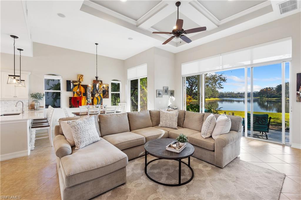 12612 Grandezza Circle Estero, FL 33928 - Photo 16 of 48 Living room featuring sink, light tile patterned floors, a high ceiling, coffered ceiling, and a water view