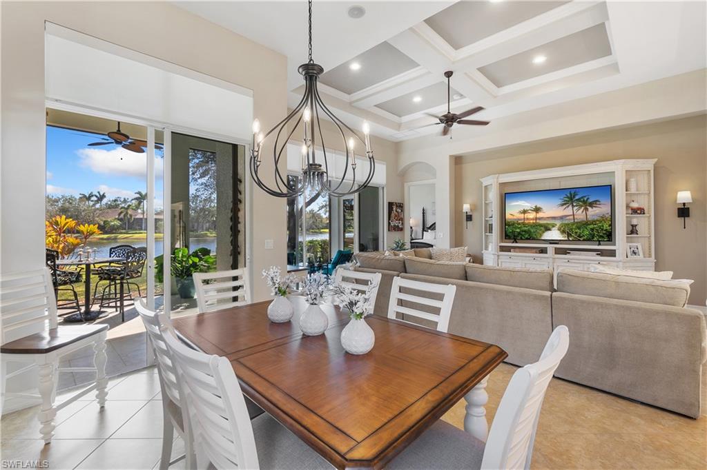 12612 Grandezza Circle Estero, FL 33928 - Photo 17 of 48 Dining space featuring light tile patterned flooring, a healthy amount of sunlight, coffered ceiling, and ceiling fan with notable chandelier