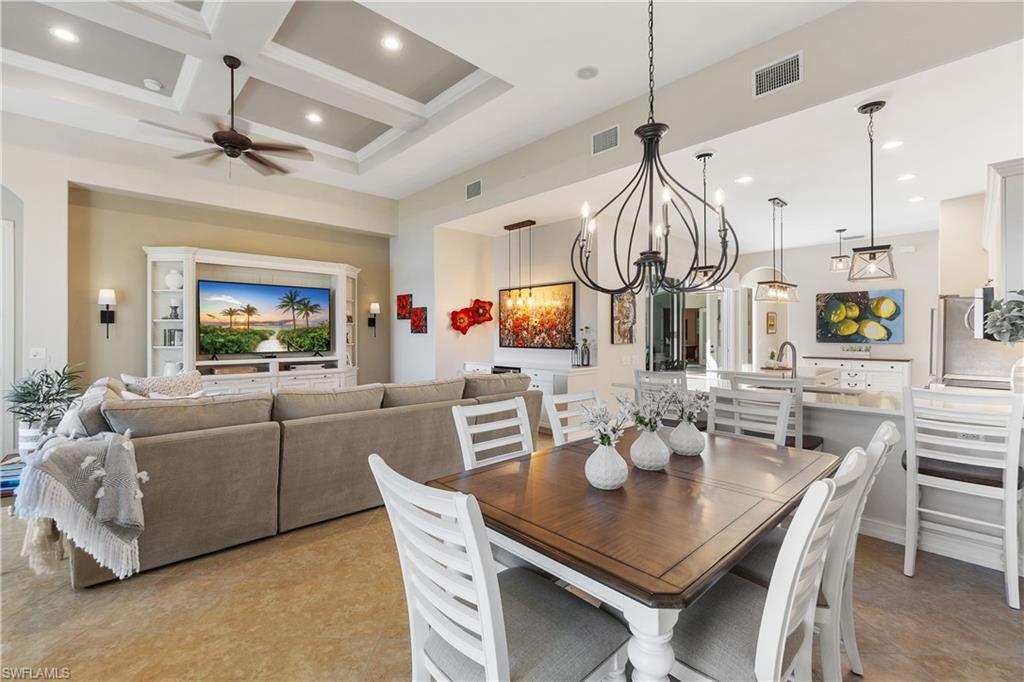 12612 Grandezza Circle Estero, FL 33928 - Photo 19 of 48 Dining area with coffered ceiling, ceiling fan with notable chandelier, beamed ceiling, and a high ceiling