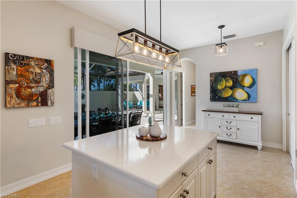 12612 Grandezza Circle Estero, FL 33928 - Photo 21 of 48 Kitchen featuring a center island, pendant lighting, white cabinets, and light tile patterned floors
