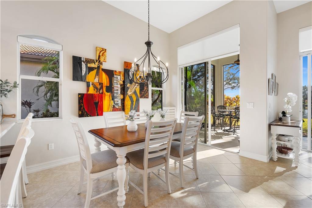 12612 Grandezza Circle Estero, FL 33928 - Photo 22 of 48 Dining area featuring light tile patterned floors, a chandelier, and a high ceiling