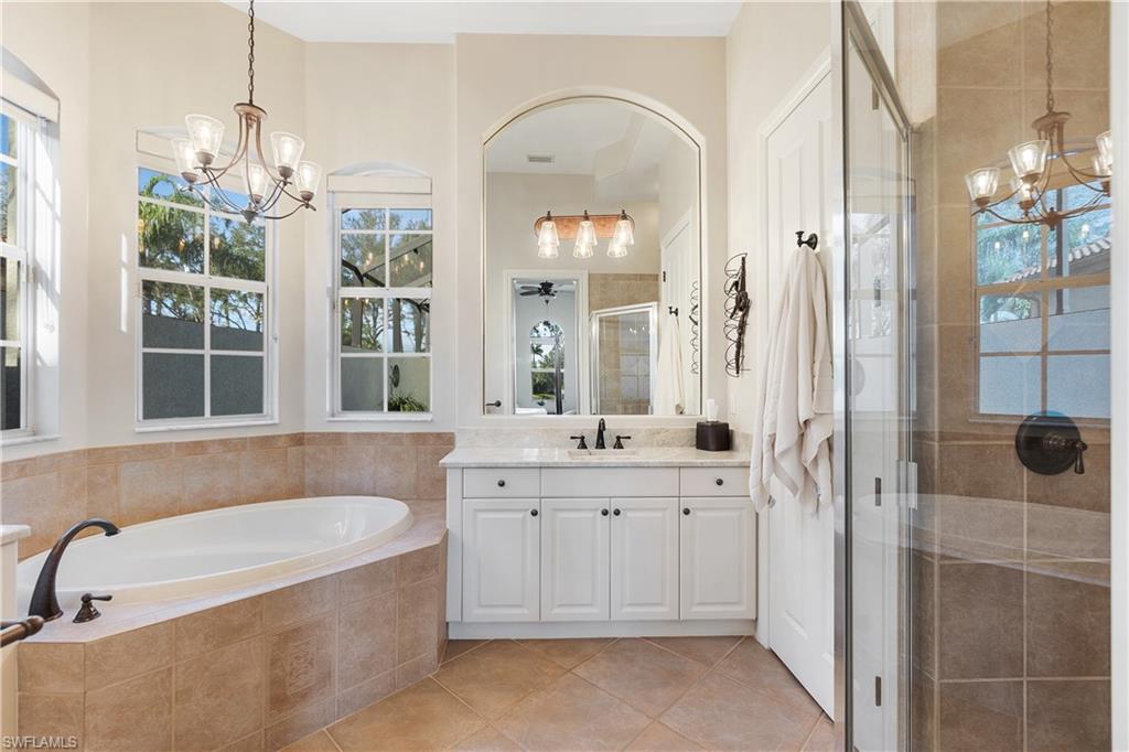 12612 Grandezza Circle Estero, FL 33928 - Photo 30 of 48 Bathroom featuring tile patterned floors, vanity, independent shower and bath, and a notable chandelier