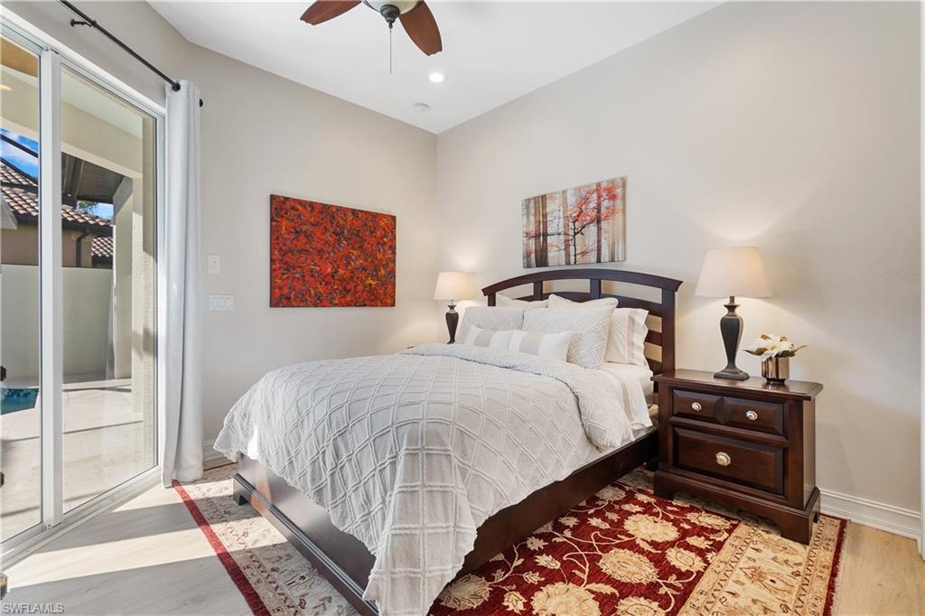 12612 Grandezza Circle Estero, FL 33928 - Photo 32 of 48 Bedroom with ceiling fan, access to exterior, and light wood-type flooring