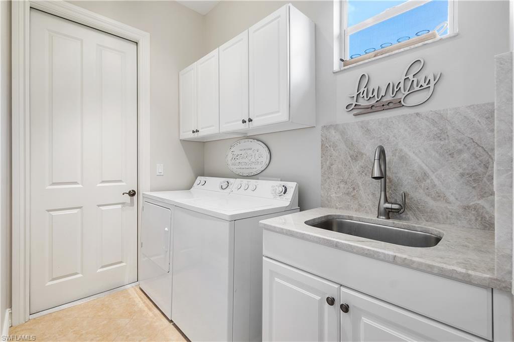 12612 Grandezza Circle Estero, FL 33928 - Photo 39 of 48 Clothes washing area with washer and dryer, sink, light tile patterned floors, and cabinets