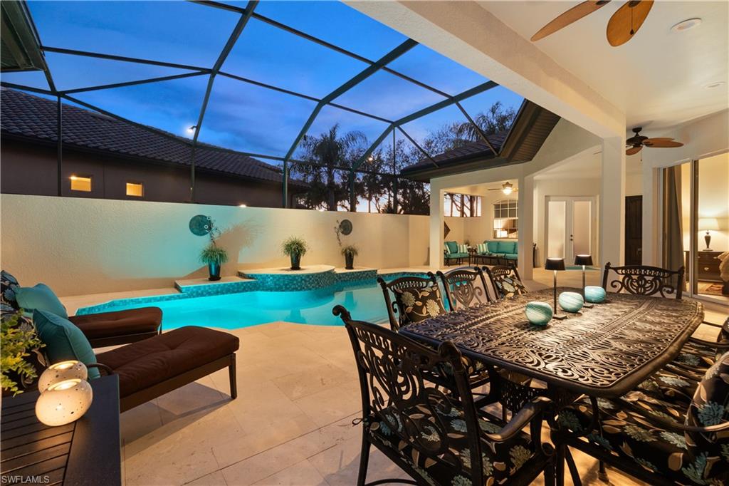 12612 Grandezza Circle Estero, FL 33928 - Photo 41 of 48 Pool at dusk with ceiling fan, glass enclosure, an outdoor hangout area, and a patio