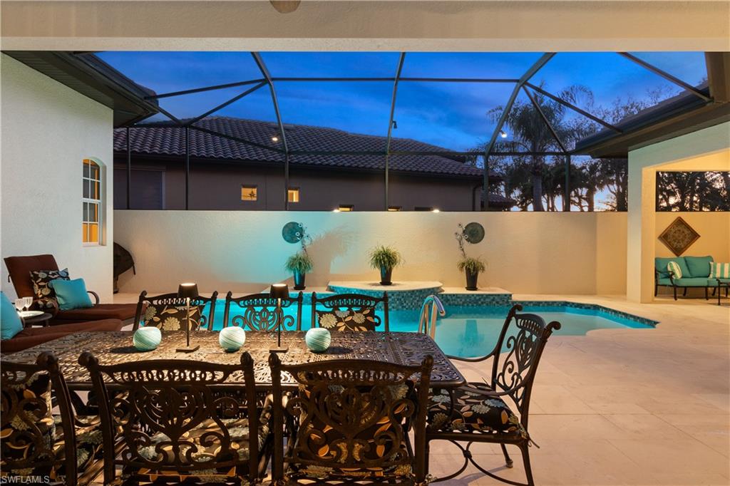 12612 Grandezza Circle Estero, FL 33928 - Photo 43 of 48 Patio terrace at dusk with a lanai and a fenced in pool