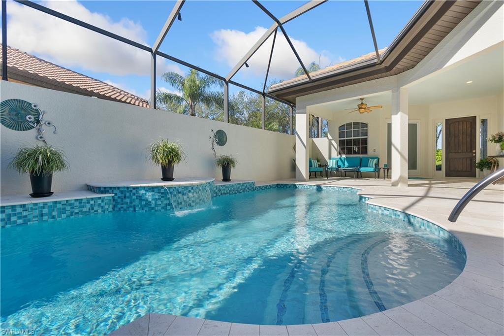 12612 Grandezza Circle Estero, FL 33928 - Photo 9 of 48 View of swimming pool with a lanai, ceiling fan, a patio, an outdoor hangout area, and pool water feature