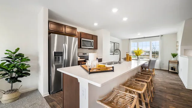 a kitchen with stainless steel appliances granite countertop sink stove and refrigerator