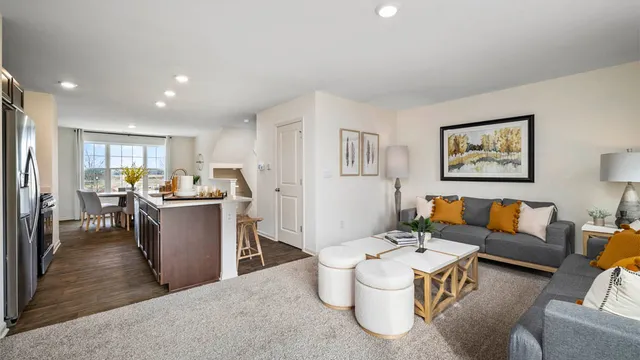 a living room with furniture and kitchen view