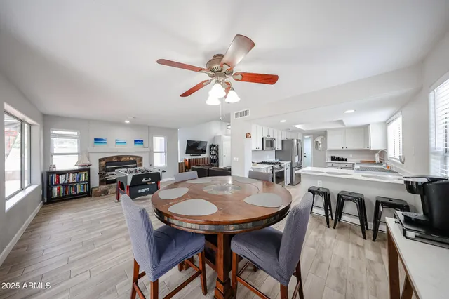 a view of a dining room with furniture a fireplace and wooden floor