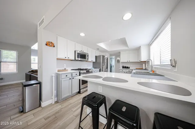 a kitchen that has a sink a stove and chairs