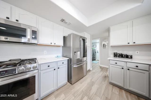a kitchen with stainless steel appliances a stove a sink and a refrigerator