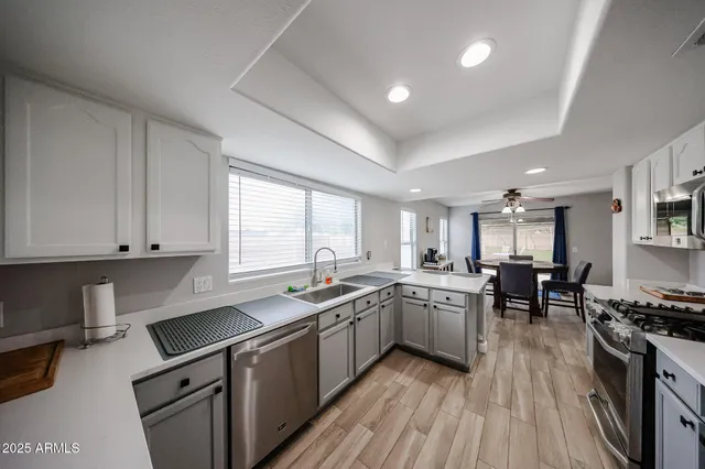 a kitchen with lot of cabinets appliances wooden floor and a window